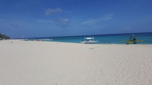 Scenic view of beach against clear blue sky