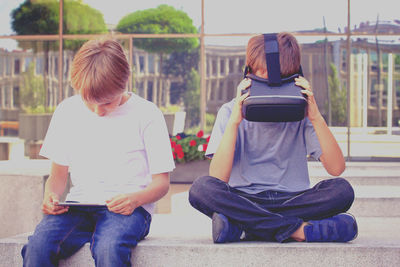 Friends using technologies while sitting on steps