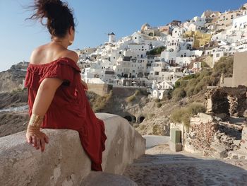 Woman standing by buildings against sky