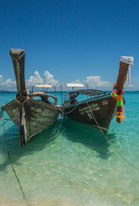 Ship moored in sea against clear blue sky