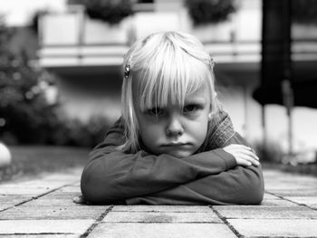 Portrait of girl lying on footpath