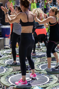 Full length rear view of women standing outdoors