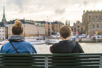 Two females sitting by gamla stan on the water