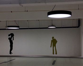 Full length of man standing against illuminated wall