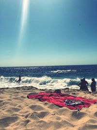 Rear view of people on beach against sky