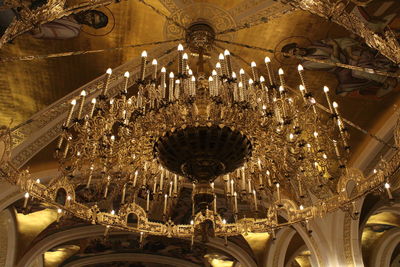 Low angle view of illuminated chandelier hanging in building