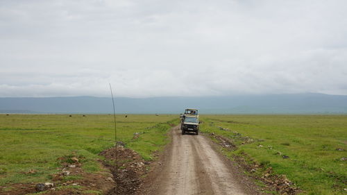 Road amidst field against sky