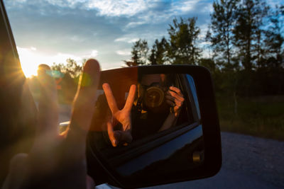 Reflection of car on mirror against sky