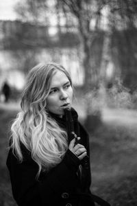 Young woman looking away while standing outdoors