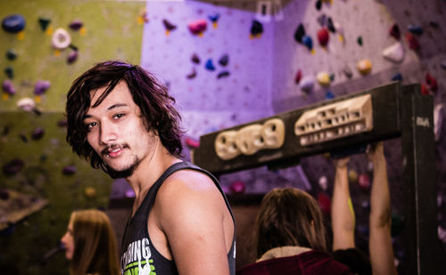 Portrait of young man against climbing wall