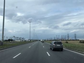 Vehicles on highway against sky