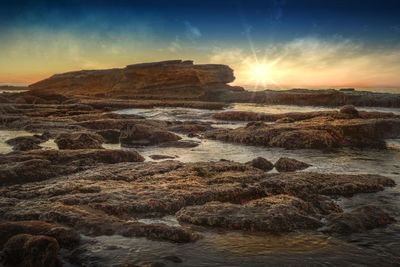 Scenic view of rocks at sunset