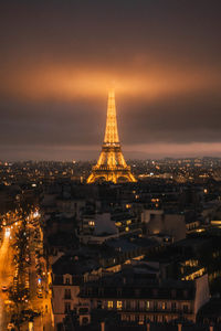 Illuminated buildings in city against sky at night