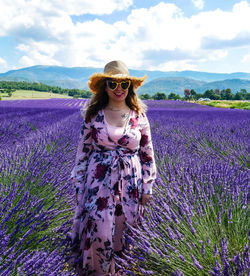 Full length of woman with a hat on a lavender field against sky