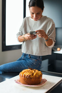 Portrait of woman holding food on table