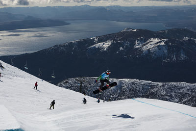 People skiing on snowcapped mountain against sky