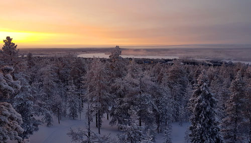 Scenic view of snow covered land during sunset