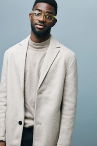 Portrait of young man standing against blue background