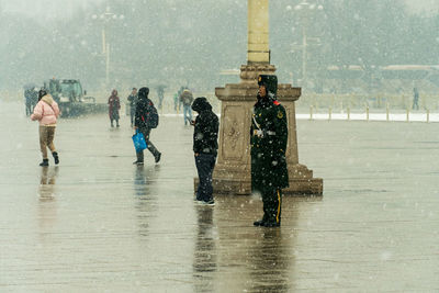 People walking on wet street during rainy season