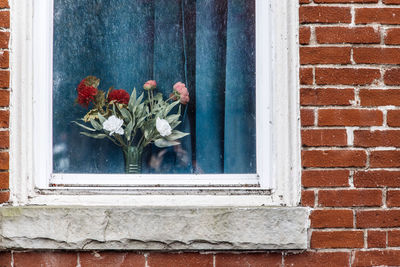 Bouquet of flowers in window with a blue curtain