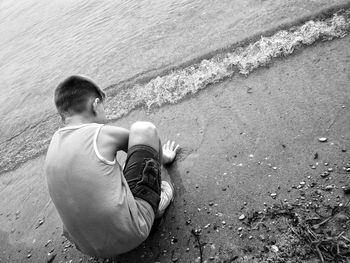 Rear view of man sitting on beach