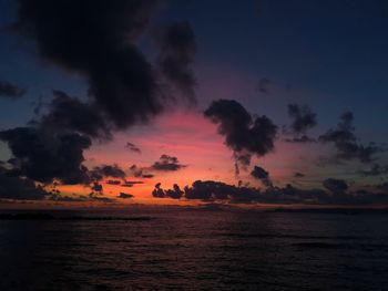 Scenic view of sea against dramatic sky during sunset