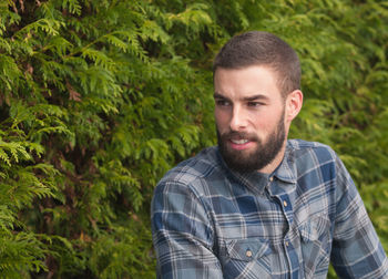 Close-up of man looking away standing by plants