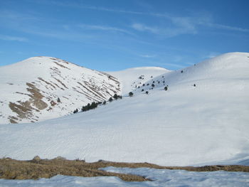 Scenic view of snow covered mountains against sky