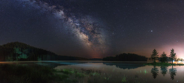 Scenic view of lake against sky at night