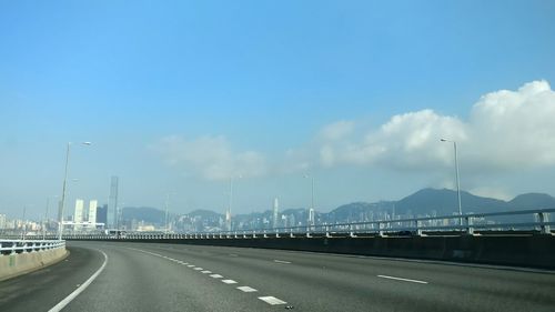 Empty road against cloudy sky