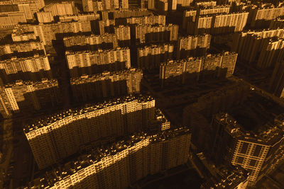 Dense development of multi-storey residential buildings illuminated by the setting sun. aerial view