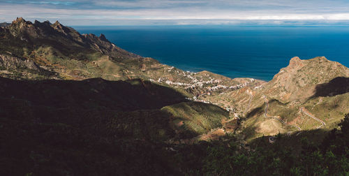 Scenic view of sea and mountains against sky