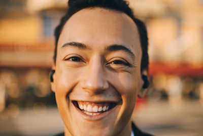 Close-up portrait of smiling young man in city