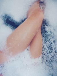 Low section of woman in bathtub