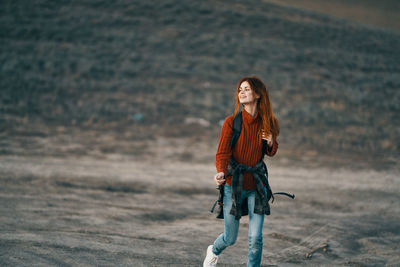 Portrait of smiling young woman standing on land