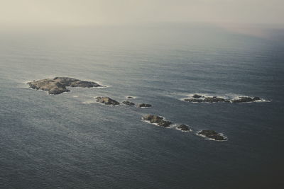 High angle view of rocks on beach against sky