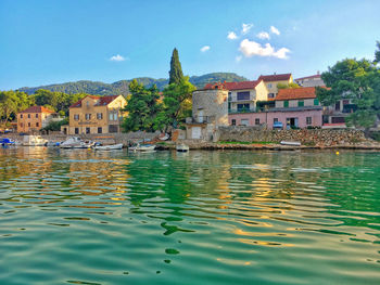 Scenic view of lake by buildings against sky