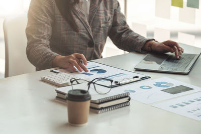 Midsection of business colleagues working on table