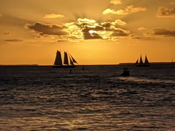 Silhouette sailboat on sea against sky during sunset
