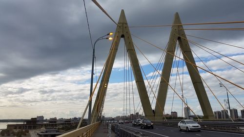 Suspension bridge against cloudy sky