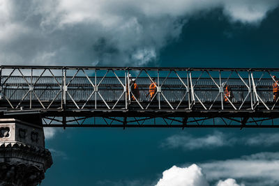 Low angle view of bridge against cloudy sky