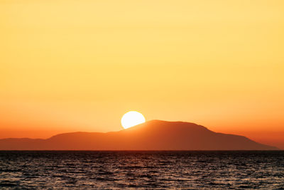 Scenic view of sea against orange sky