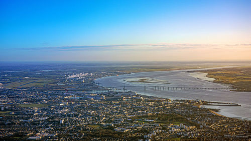 High angle view of sea and buildings against sky during sunset