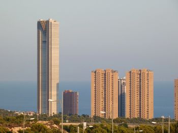 Modern buildings in city against clear sky