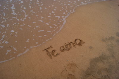 High angle view of i love you on sand at beach