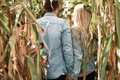 Rear view of couple standing by plants