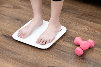 Low section of woman standing on hardwood floor