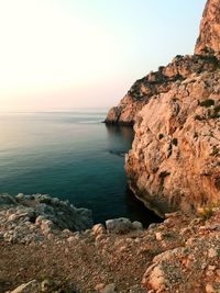 Scenic view of rocks in sea against clear sky