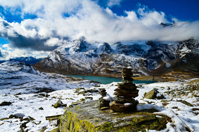 Cairn showing the way in the snowy landscape of the bernina pass region, engadin, switzerland