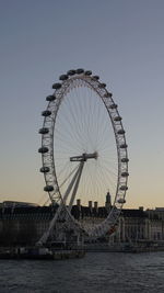 Ferris wheel in city against clear sky